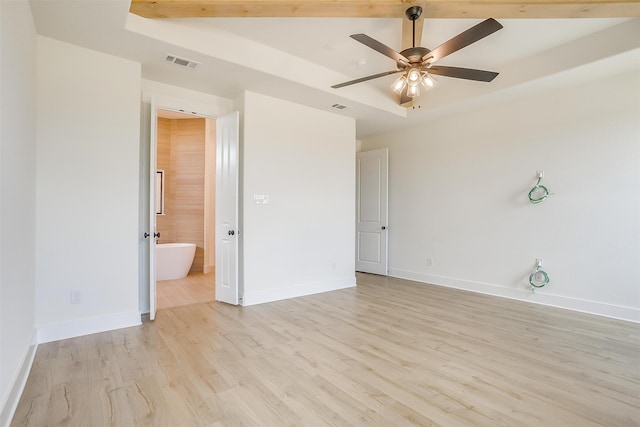 unfurnished bedroom with a tray ceiling, light hardwood / wood-style flooring, ensuite bathroom, and ceiling fan