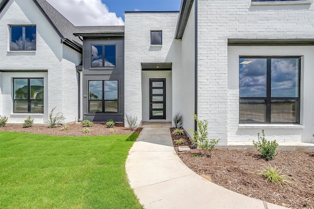 doorway to property with a lawn