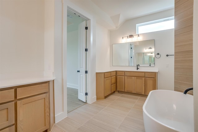 bathroom with vanity, a bath, and tile patterned floors