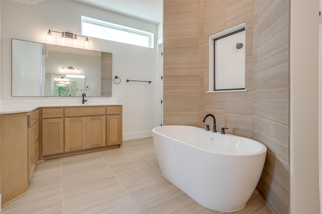 bathroom featuring a tub to relax in, vanity, tile walls, and tile patterned flooring