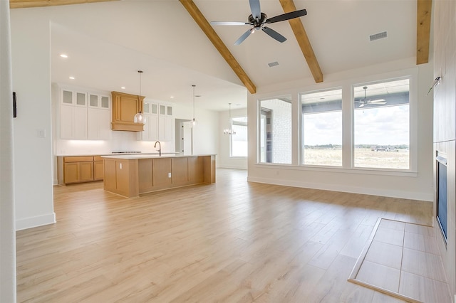 kitchen featuring a center island with sink, pendant lighting, ceiling fan, and a wealth of natural light