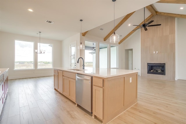 kitchen with a fireplace, beamed ceiling, ceiling fan with notable chandelier, dishwasher, and a center island with sink