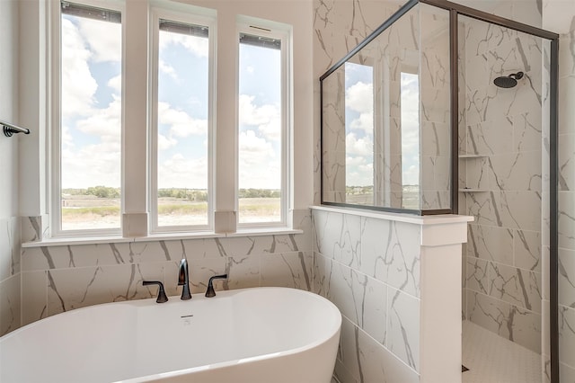 bathroom featuring plenty of natural light and independent shower and bath