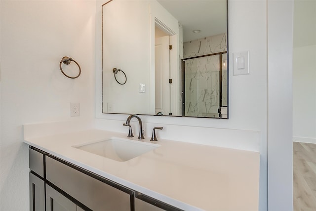 bathroom featuring vanity, wood-type flooring, and an enclosed shower