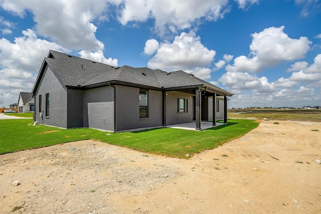 rear view of property with a lawn and a patio