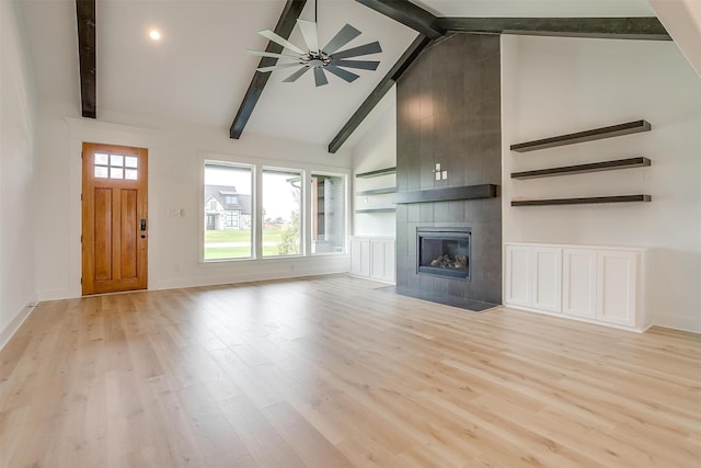 unfurnished living room with a fireplace, light wood-type flooring, high vaulted ceiling, ceiling fan, and beam ceiling