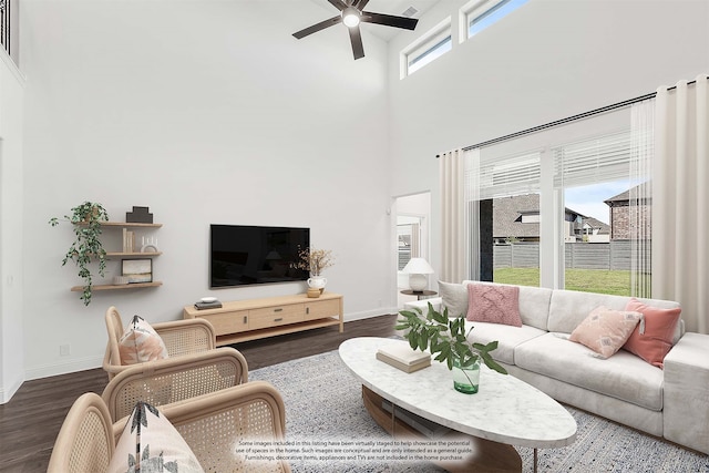 living room with a towering ceiling, a wealth of natural light, and dark hardwood / wood-style flooring