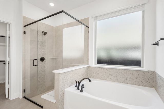 bathroom with tile patterned floors and shower with separate bathtub