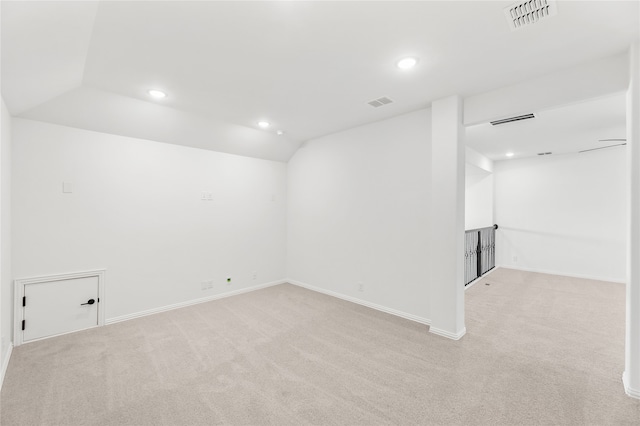 carpeted empty room with vaulted ceiling