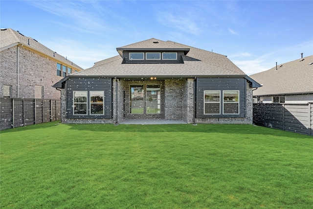 rear view of property with a patio and a lawn