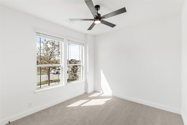 unfurnished room featuring a wealth of natural light, light carpet, and ceiling fan