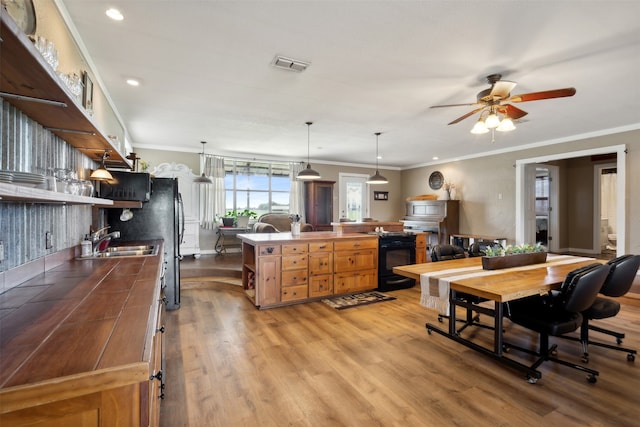 kitchen featuring sink, ornamental molding, and hanging light fixtures