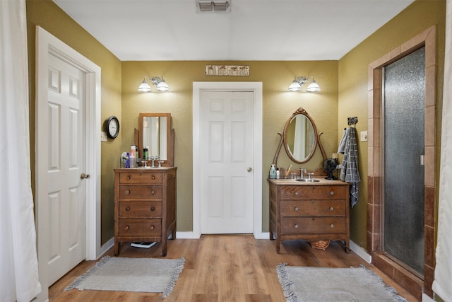 bathroom with vanity, an enclosed shower, and wood-type flooring