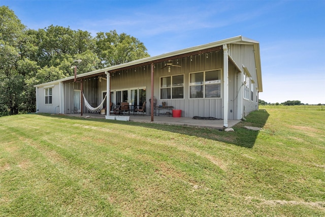 rear view of house featuring a patio area and a lawn