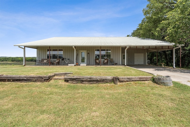 view of front of home with a front lawn, covered porch, a garage, and a carport