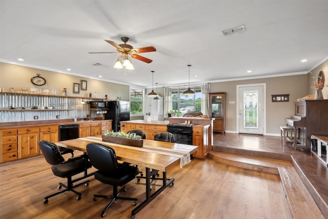 dining area with ceiling fan, light wood-type flooring, and ornamental molding