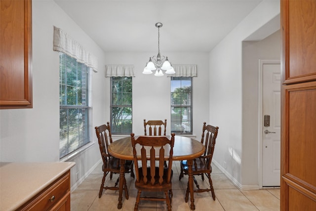 tiled dining room featuring an inviting chandelier