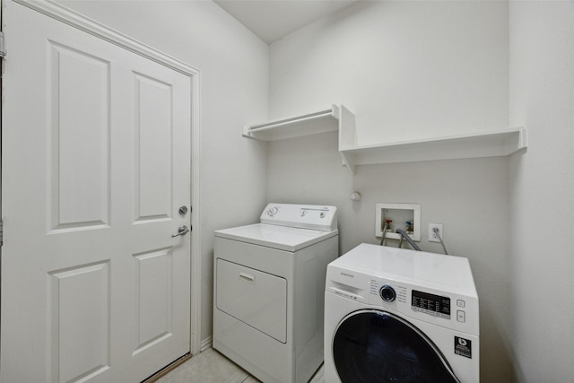 laundry room featuring light tile patterned floors and washing machine and clothes dryer