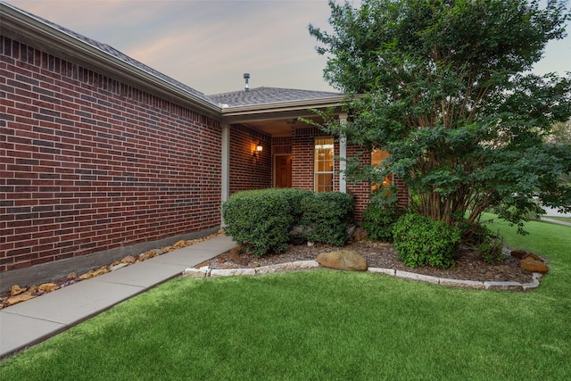 exterior entry at dusk featuring a yard