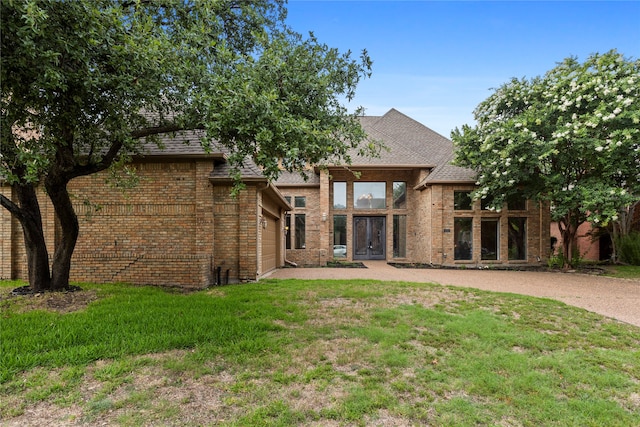 back of house with a garage and a lawn