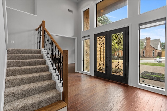 foyer featuring french doors, dark hardwood / wood-style flooring, and a high ceiling