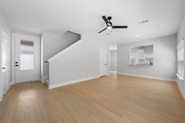 unfurnished living room featuring ceiling fan, light hardwood / wood-style floors, and a wealth of natural light