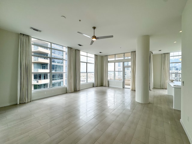 unfurnished room featuring floor to ceiling windows and ceiling fan