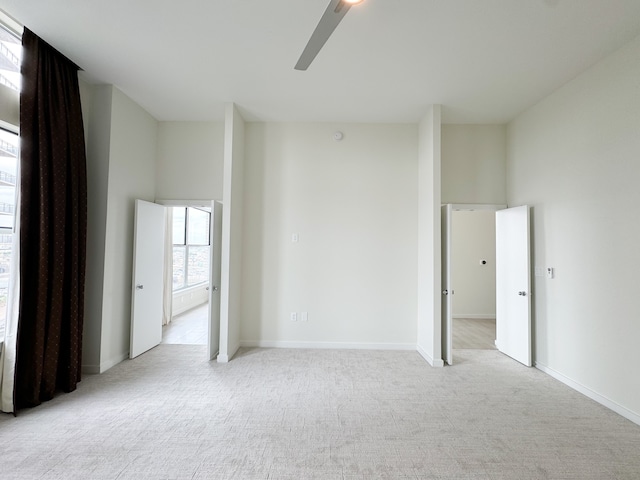 interior space with ceiling fan and light carpet