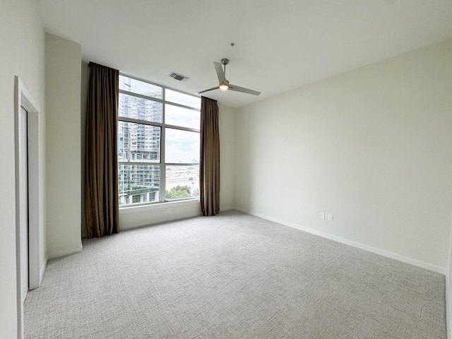 spare room featuring light carpet and ceiling fan