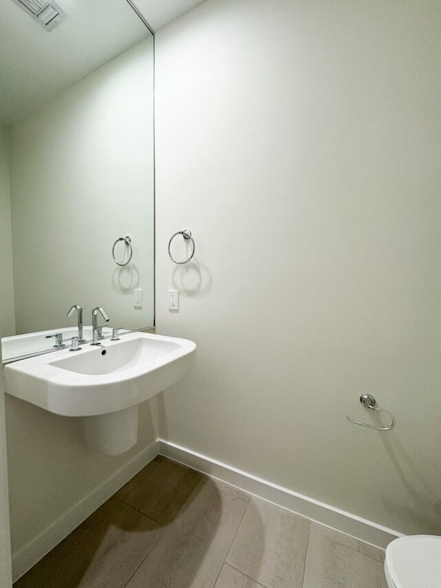 bathroom with tile flooring, sink, and toilet