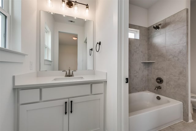 full bathroom with tile patterned flooring, vanity, toilet, and tiled shower / bath