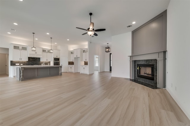 unfurnished living room with ceiling fan and light wood-type flooring