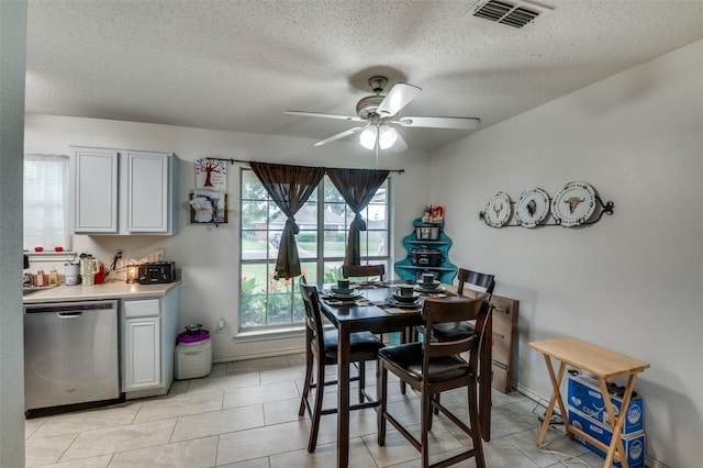 dining space featuring a textured ceiling, ceiling fan, and light tile floors