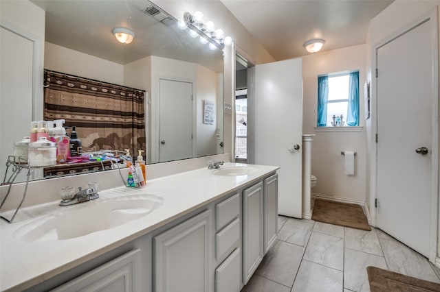 bathroom featuring tile flooring, double sink vanity, and toilet