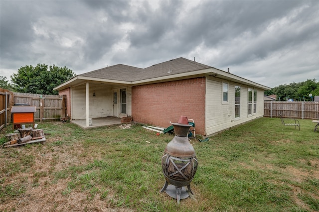 rear view of property with a patio and a yard