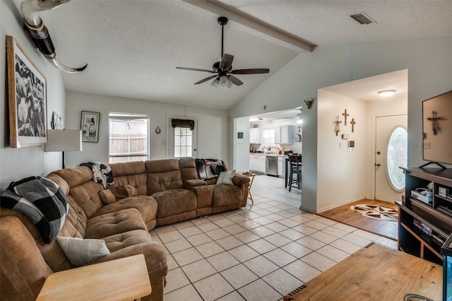 living room featuring a textured ceiling, lofted ceiling with beams, ceiling fan, and light tile floors