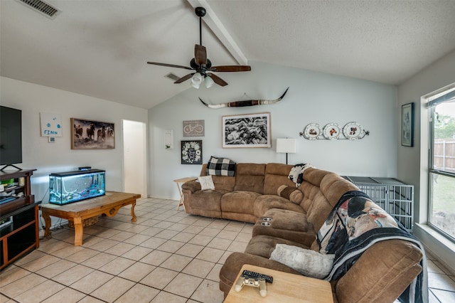 living room featuring lofted ceiling with beams, light tile flooring, and ceiling fan