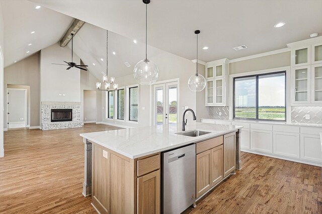 kitchen featuring tasteful backsplash, light brown cabinetry, sink, light wood-type flooring, and stainless steel dishwasher