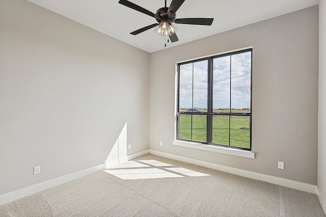 carpeted empty room featuring a wealth of natural light and ceiling fan