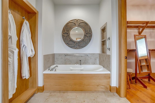 bathroom with a bathing tub and hardwood / wood-style floors