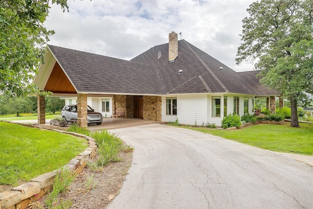 view of front of home with a carport and a front lawn