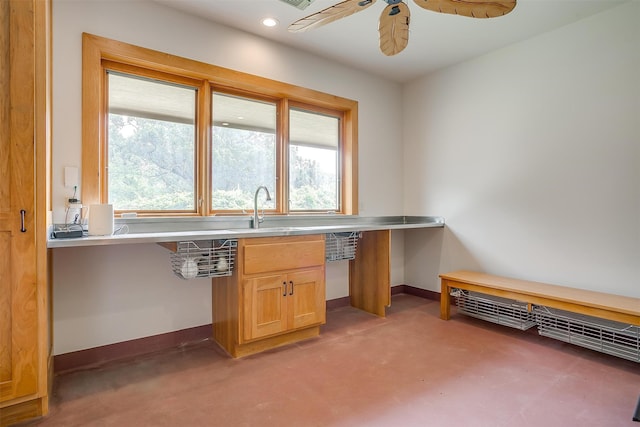 unfurnished office with ceiling fan, a healthy amount of sunlight, and sink