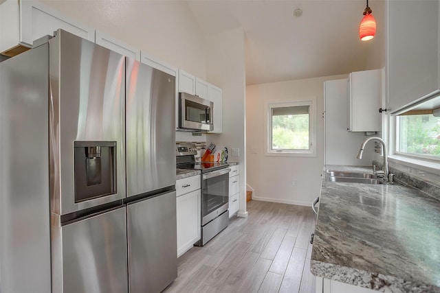 kitchen featuring stainless steel appliances, hanging light fixtures, sink, and white cabinets