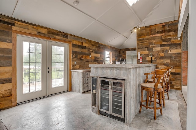 interior space featuring concrete floors, wood walls, and lofted ceiling