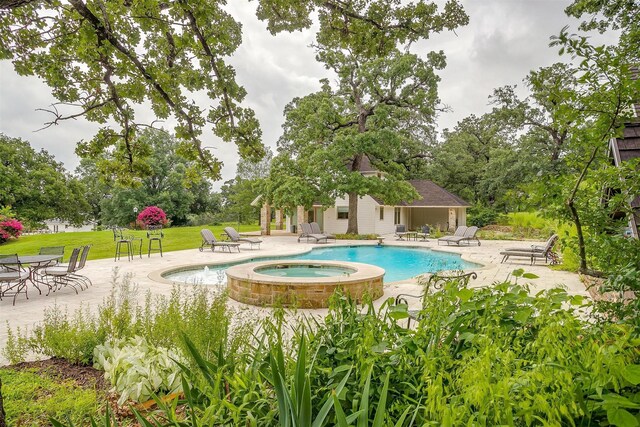 view of swimming pool featuring a patio area and an in ground hot tub