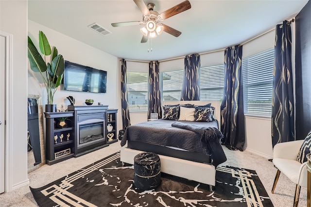 bedroom with carpet flooring, ceiling fan, and multiple windows