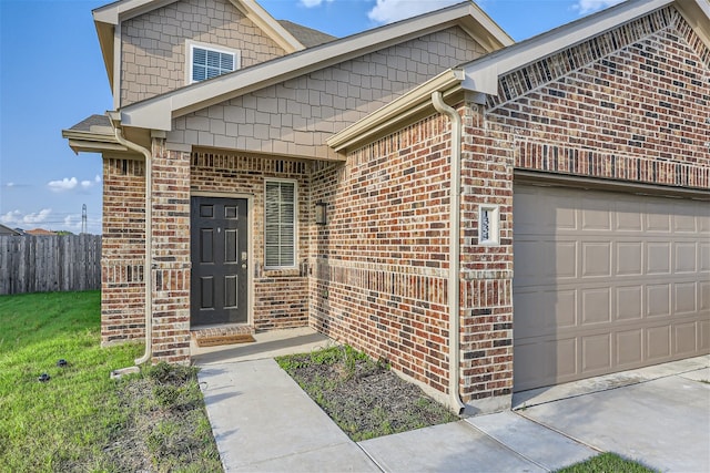 doorway to property with a garage and a yard