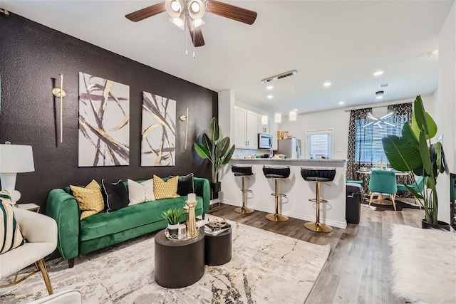 living room featuring ceiling fan and hardwood / wood-style floors