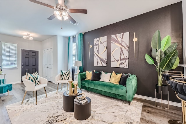 living room with a wealth of natural light, wood-type flooring, and ceiling fan