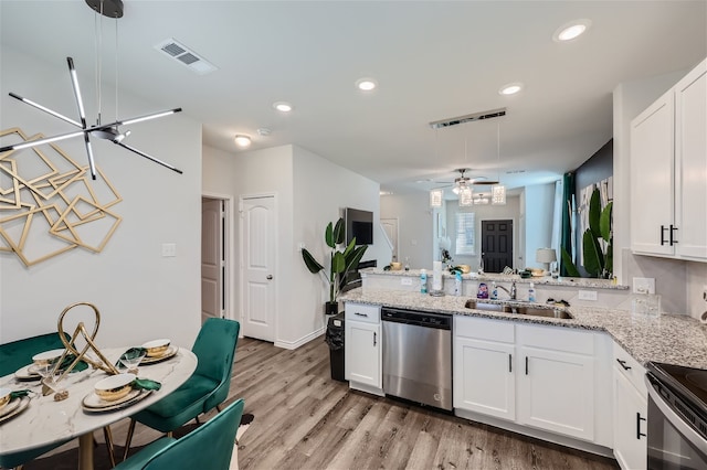 kitchen with white cabinets, ceiling fan, stainless steel dishwasher, and light wood-type flooring